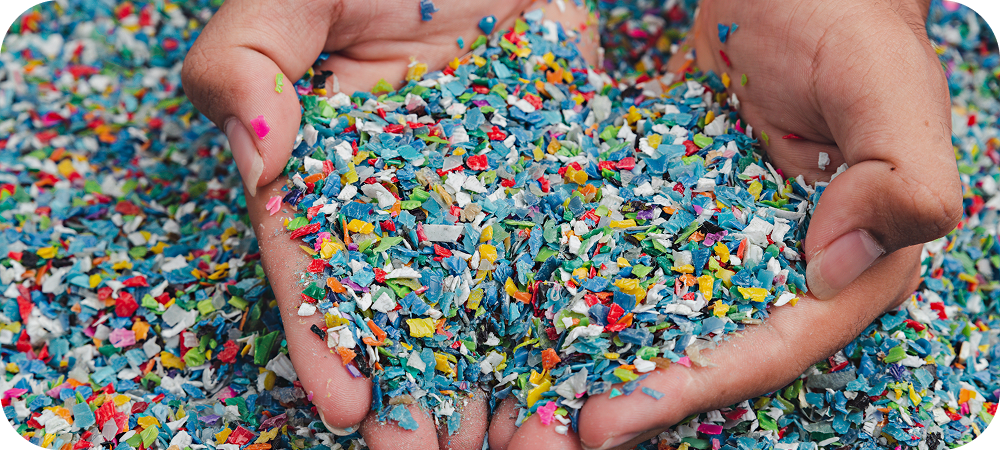 Hands holding colorful recycled plastic pieces