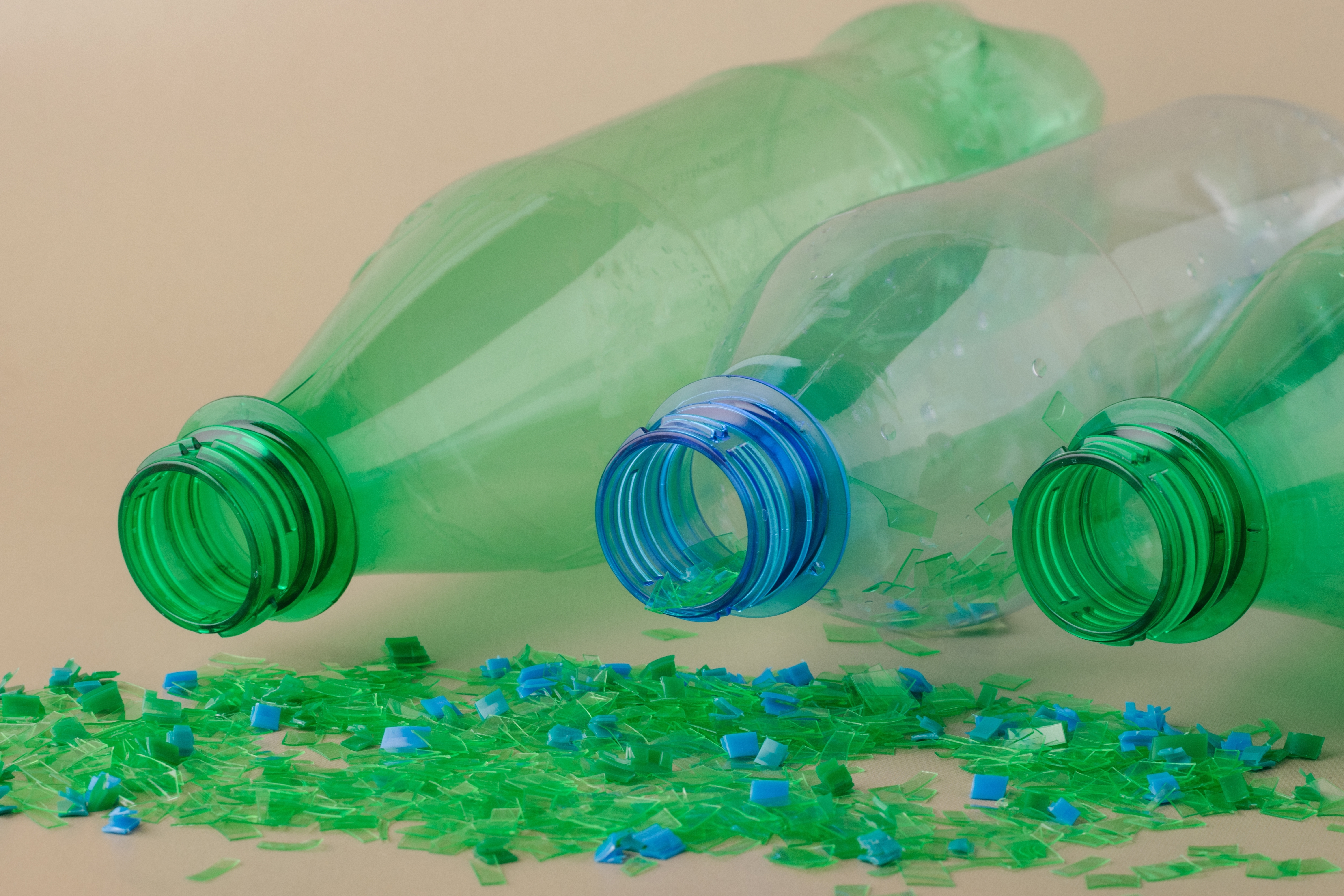 Plastic bottles and recycled plastic flakes representing plastic recycling and sustainability.